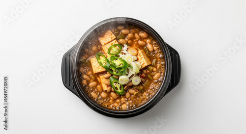 A steaming hot bowl of Korean fermented soybean stew, Cheonggukjang, with tofu and green chili.