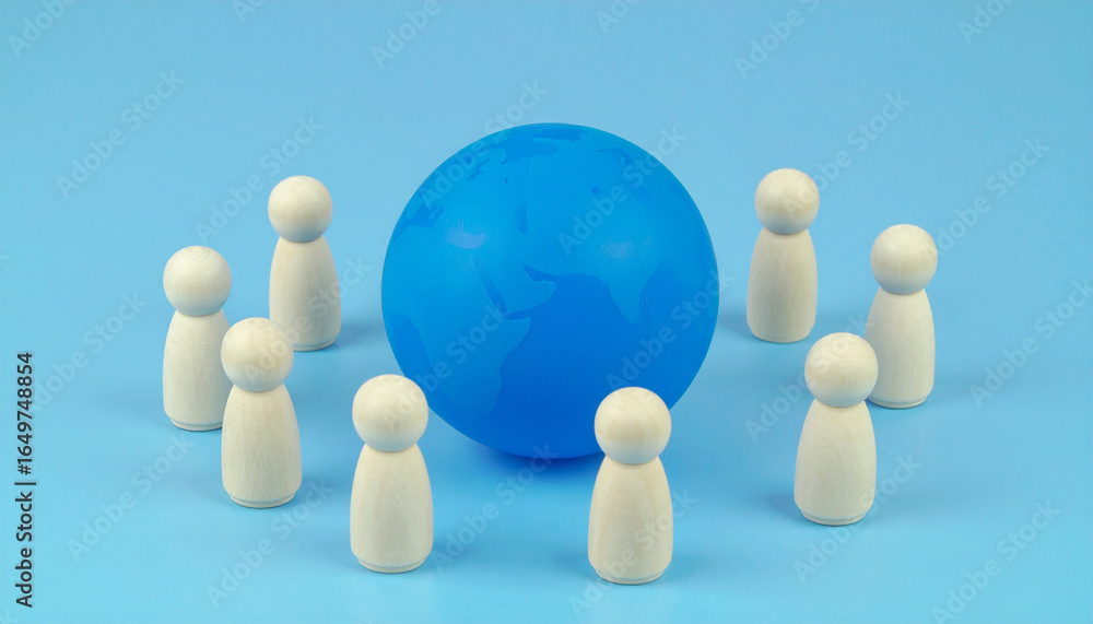 Obraz premium Miniature wooden team figures around abstract blue globe model, global collaboration concept.