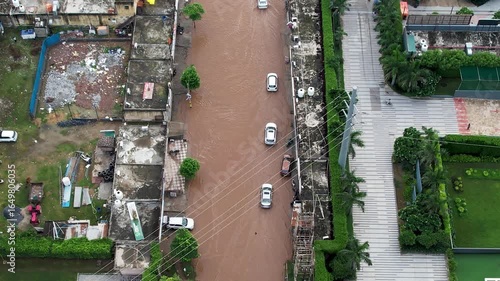 Aerial drone shot cars crossing flooded streets leading to damage and delays owing to poor road infrastructure and poor maintenance in Gurgaon, Delhi, Bangalore, Mumbai India during monsoons