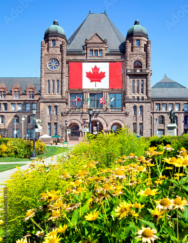 Photography Ontario Legislative Building at Queen's Park with large Canadian flag and flower