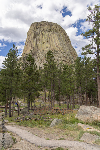 Devils Tower National Monument blue sky white clouds trees