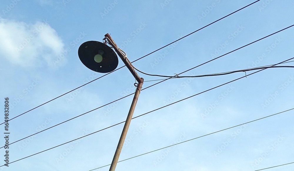 Obraz premium The lamp post is a source of lighting with electrical cables around it. 