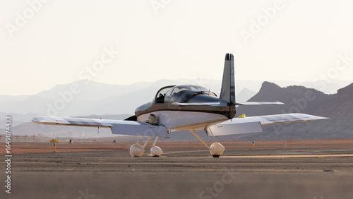 A small airplane sits on the tarmac at a local airport in Southern Utah USA with the cockpit open waiting for the preparations to be complete before an early morning flight.