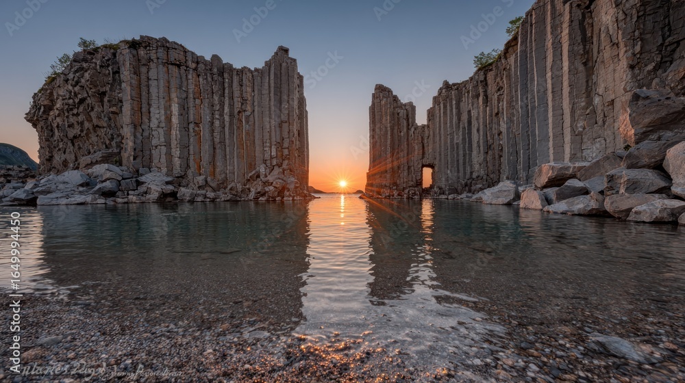 Sunrise through basalt columns, calm water Sunrise through basalt columns, calm water