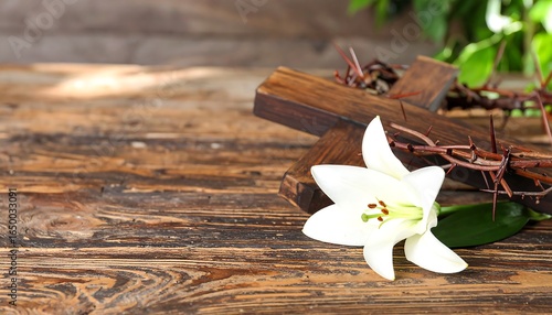 Wooden cross with crown of thorns and lily on rustic table.