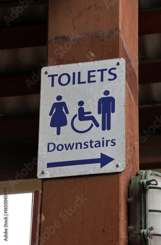Konstfotografi Toilets Downstairs sign with symbols for male, female and disabled access attach