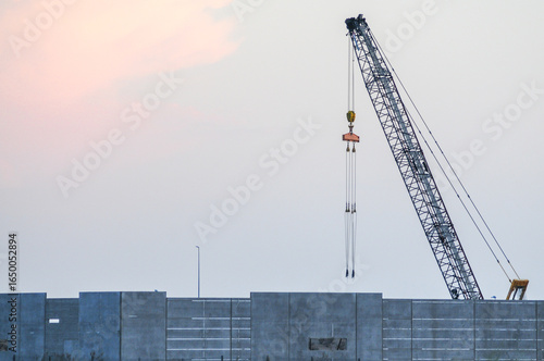 Canvastavla A crawler crane lifts prefabricated concrete wall panels into position at a reta