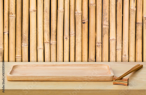 Empty sushi board on wood table with bamboo background. Top view of plank wood for graphic stand product, interior design or montage display your product.