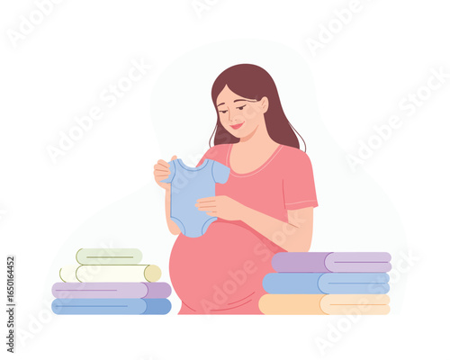 Happy expectant mother prepares for newborn, organizing tiny baby clothes and holding a cute blue onesie.