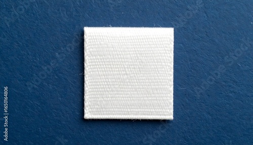 Blank white fabric label against a deep blue background.