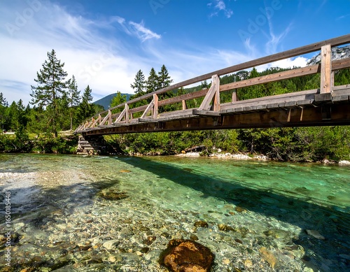 Rustic wooden bridge spanning a pristine alpine river with turquoise water