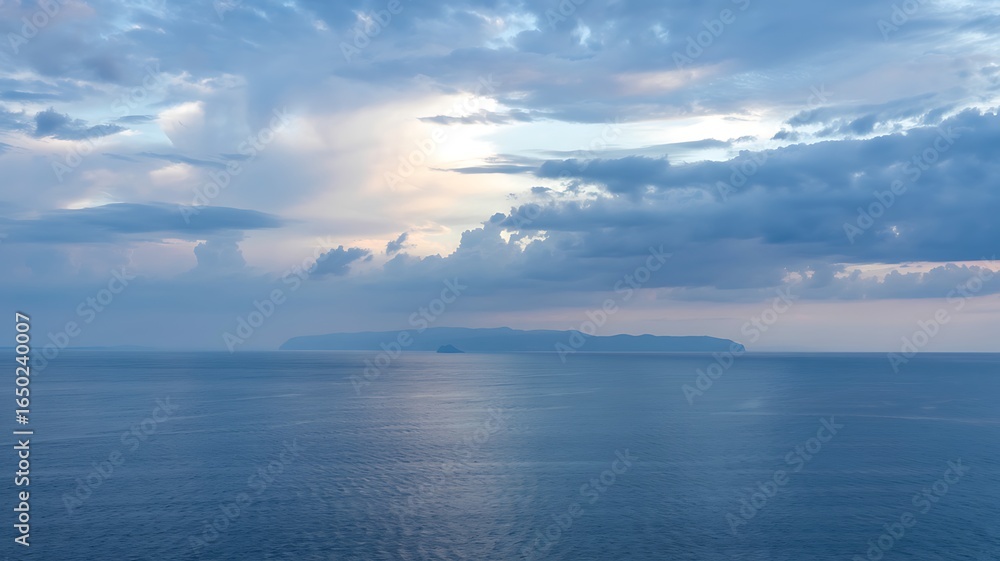Fototapeta premium Serene ocean vista with dramatic clouds and sunlight breaking through reflecting on calm water surface