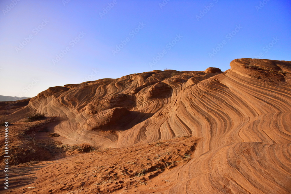 Naklejka premium Sandy Dunes with Wavy Patterns Under a Clear Blue Sky