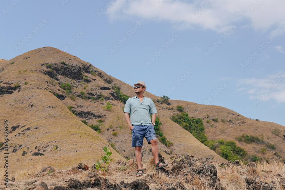 Fototapeta premium Happy young Asian man enjoying holiday in Golo Mori mountain hill, Labuan Bajo.