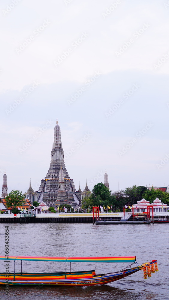 Fototapeta premium Boat trip on the Chao Phraya River with Wat Arun in the background in Bangkok, Thailand.