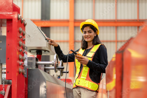 woman engineer worker check and control material planning to inspect and repair equipment in production line, labor people in safety vest and helmet working at industrial manufacturing factory