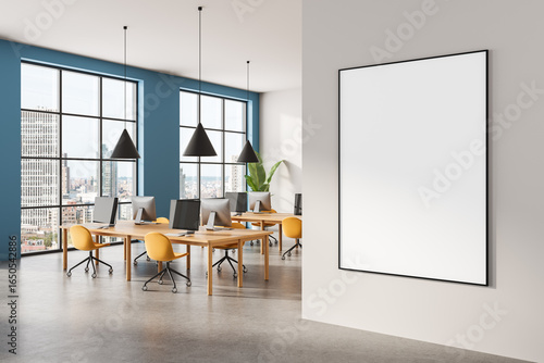 Tableau sur toile Modern office interior with large blank wall poster mockup and colorful workspace furniture in daylight city view setting