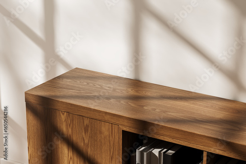 Wooden storage cabinet mockup in modern interior with natural sunlight casting shadows on white wall surface. 3D Rendering