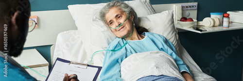 Fotografía Header of senior Caucasian woman lying in hospital bed wearing oxygen tube, look