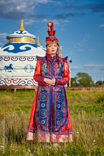 Fényképezés Mongolian girls dressed in luxurious Mongolian costumes in front of a yurt on th