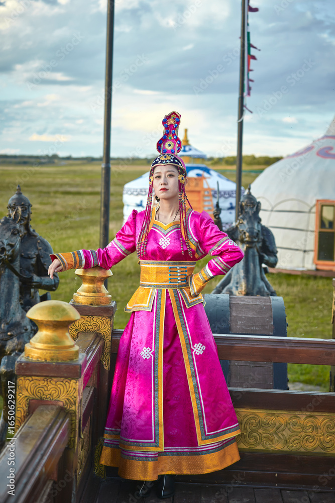Naklejka premium Mongolian girls dressed in luxurious Mongolian costumes on the Mongolian war chariots of the Jinyuan Grand Tent on the grassland