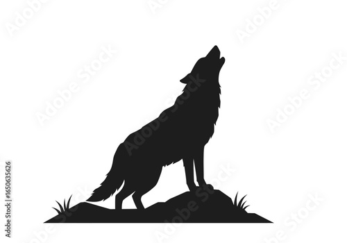 Silhouette of a wolf howling atop a rocky mound with grass captured in a monochrome stark contrast