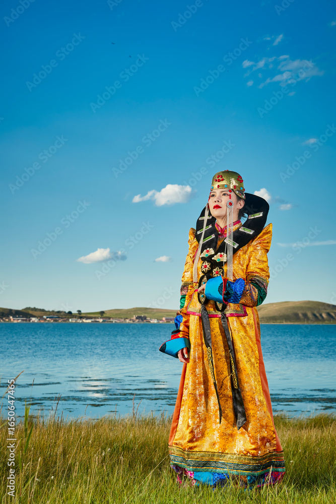 Fototapeta premium Mongolian girls dressed in luxurious Mongolian costumes on the grassland