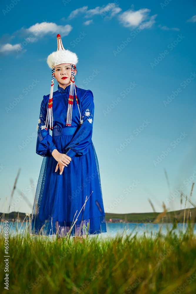 Fototapeta premium Young Mongolian sisters wearing traditional Mongolian clothing on the grassland