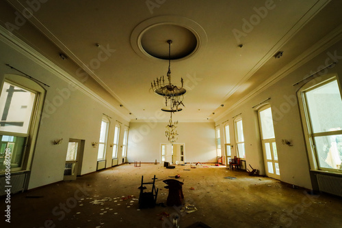 hallway of an old hotel with chandeliers and chairs