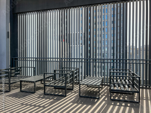 Modern outdoor seating area with metal furniture and vertical blinds