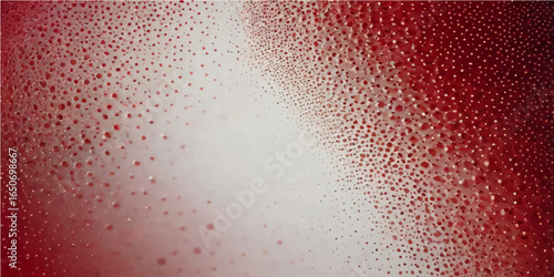 Wet drops of water on a red glass texture create an abstract pattern of bubbles and light
