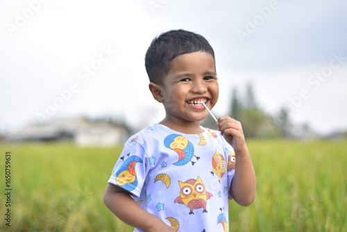 3 year old Asian child with a cheerful face and thumbs up