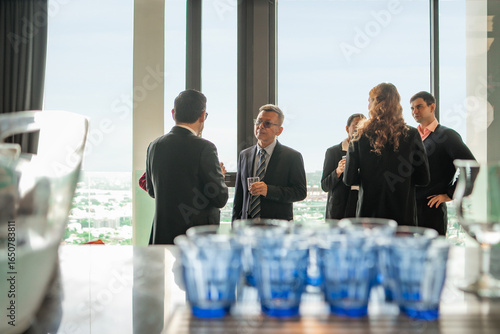 Foto Business meeting meets leisure at a rooftop hotel cocktail party, where guests mingle, share ideas, and enjoy spectacular skyline views