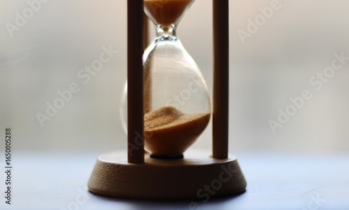 Hourglass on the windowsill in the evening time passes photo	
