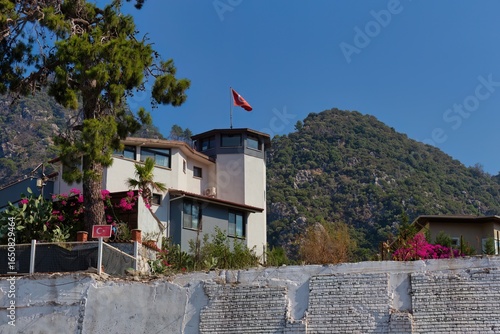 Tableau sur toile A modern house sits nestled against a mountain backdrop under a clear blue sky i