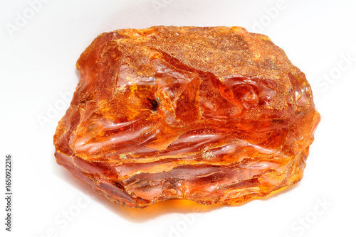 One piece of amber with patterns on the white background. Sun stone. Fossil fossilized resin. semi-precious mineral. Natural material for jewelry. Copal. Science.  Polished amber stone.