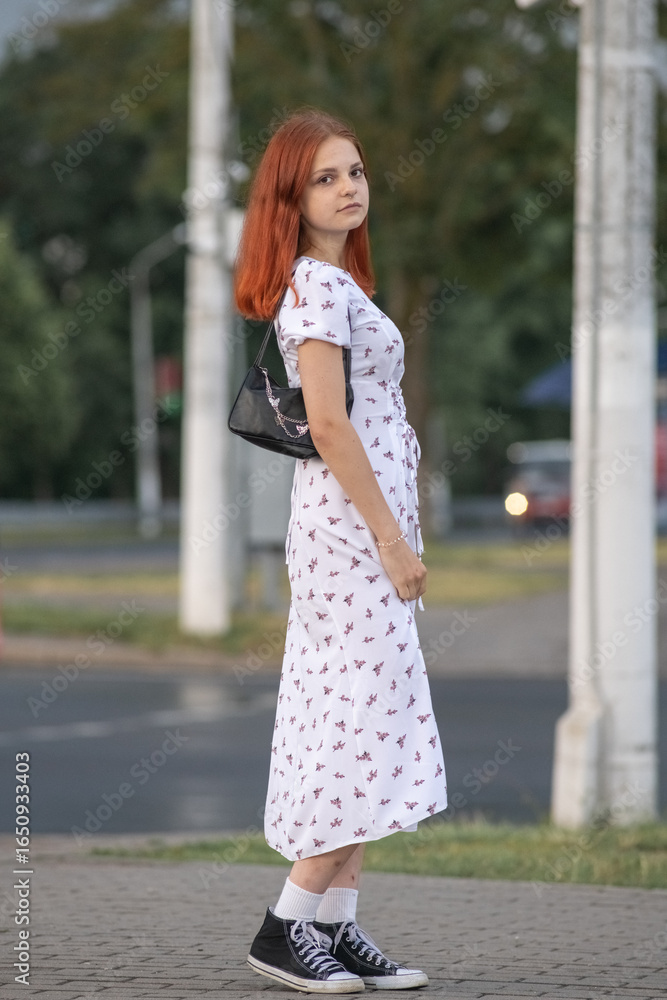 Obraz premium Young beautiful girl in a light dress having fun outdoors on a summer day.