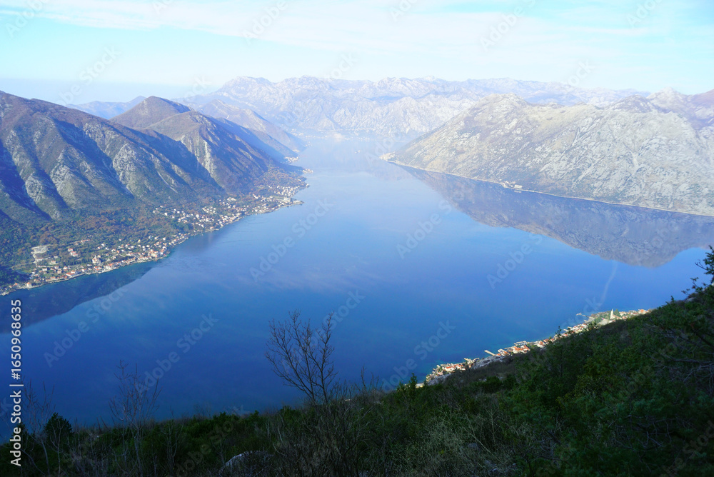 Fototapeta premium Mountain hiking reward overlooking Kotor bay, Montenegro. Breathtaking panoramic vista from Dinaric Alps trail. Adventure travel, outdoor recreation, summit photography, wilderness exploration concept