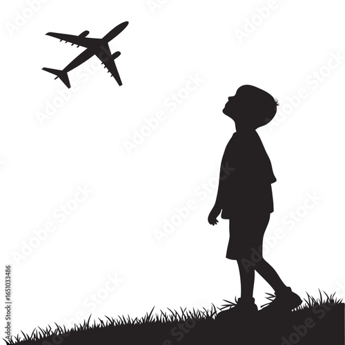 Silhouette of a boy watching an airplane flying overhead in the sky