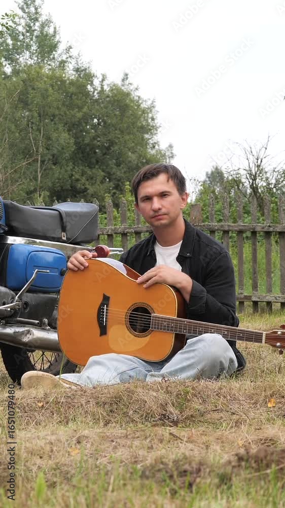 vertical video Musician camping with motorcycle and guitar near bonfire vertical video Musician camping with motorcycle and guitar near bonfire