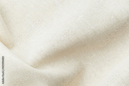 Natural beige fabric textile with soft folds and texture close up