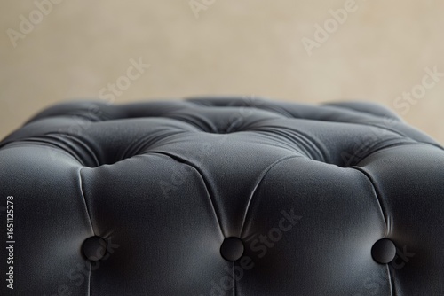 Close-up of a luxurious, gray-toned, tufted upholstery with elegant button detailing, creating a sophisticated and comfortable aesthetic.