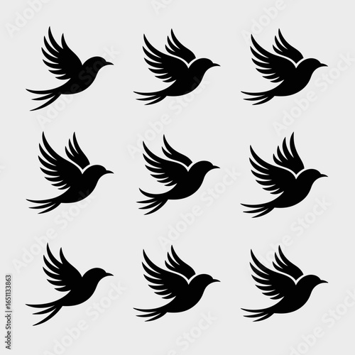 Collection of nine black flying bird silhouettes isolated on white background