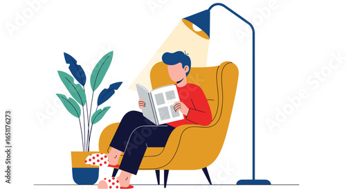 Young man reading book in armchair with floor lamp and plant