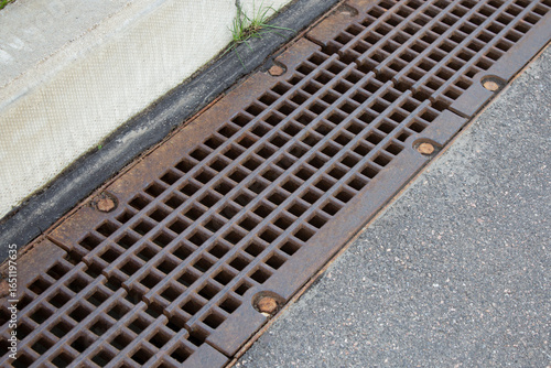 Cast Iron gully drain cover on urban street. Protection against storm and rain