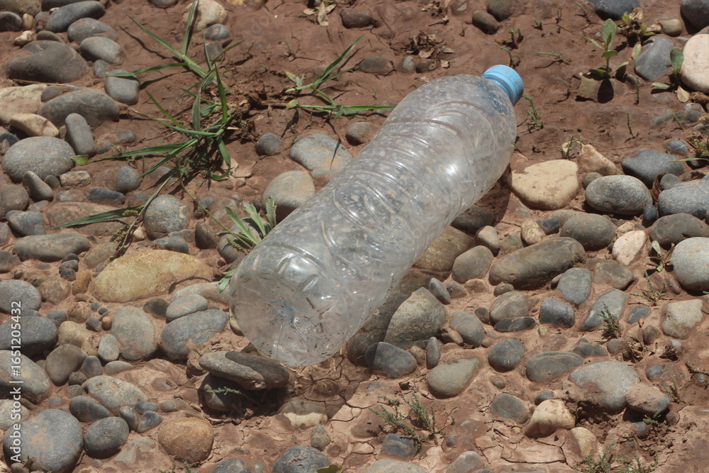 Obraz premium A plastic bottle lying on the ground, Plastic pollution