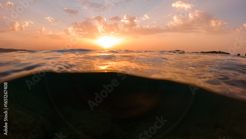 Fotografía Underwater part and sunset skylight splitted by waterline, underwater bubbles