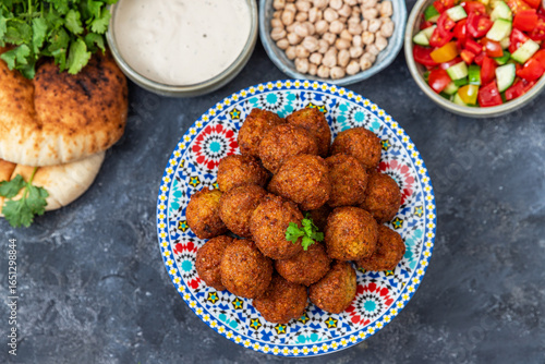 Traditional homemade chickpea Falafel balls with vegetables salad , tahini sauce,chips and pita bread. Vegetarian food concept.	