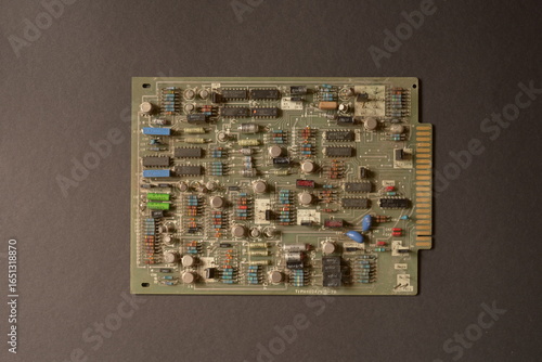 Vintage electronics circuit board with resistors, capacitors, and microchips
