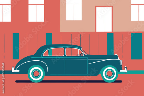 Vintage teal sedan parked on street with buildings